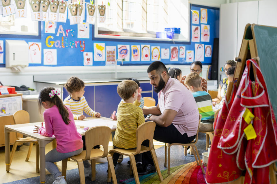 A man working with kids in a classroom