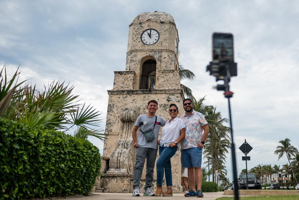 From left, Raul Dominguez, Andrea Jimenez, and Rodrigo Saez, all visiting from Santiago, Chile, smile and pose for a picture underneath the Worth Avenue Clock Tower in Palm Beach.