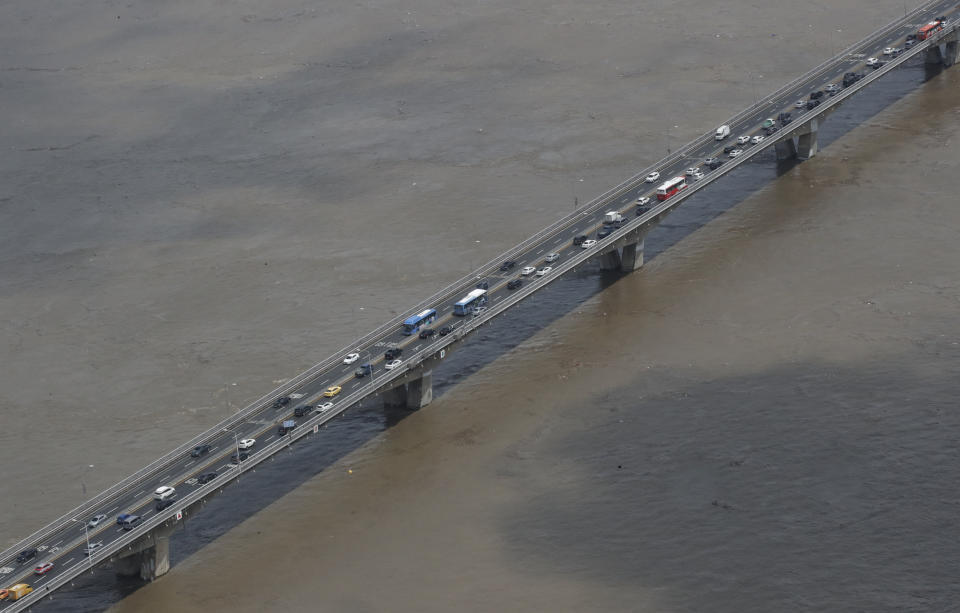 The Han River, swollen with floodwater, flows under a bridge in Seoul, South Korea, Thursday, Aug. 6, 2020. On Thursday, the state-run Han River Flood Control Office issued a flood alert near a key river bridge in Seoul, the first such advisory since 2011. (AP Photo/Lee Jin-man)