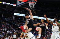 Houston Rockets center Alperen Sengun (28) falls over Denver Nuggets guard Jamal Murray (27) during the second quarter of an NBA basketball game Wednesday, Nov. 30, 2022, in Denver. (AP Photo/Jack Dempsey)