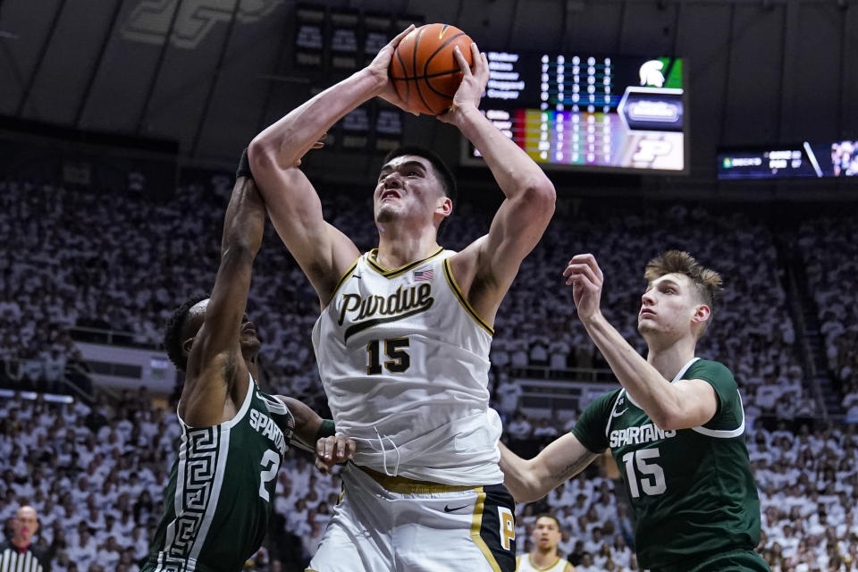 Purdue center Zach Edey (15) shoots between Michigan State guard Tyson Walker (2) and center Carson Cooper (15) during the second half of an NCAA college basketball game in West Lafayette, Ind., Sunday, Jan. 29, 2023. Purdue defeated Michigan State 77-61. (AP Photo/Michael Conroy)