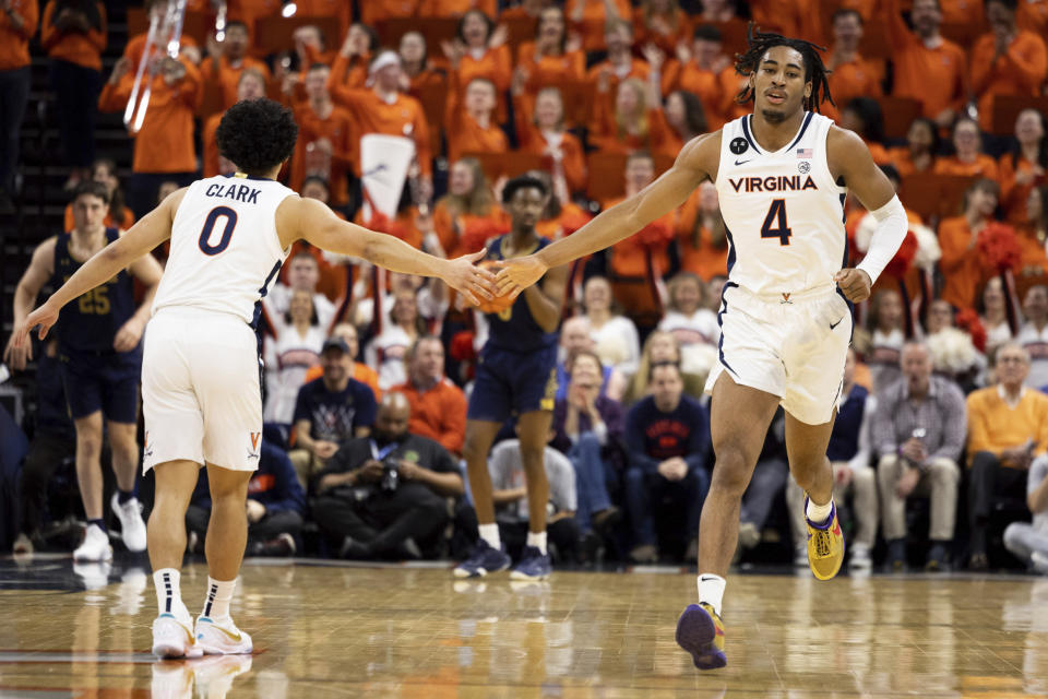 Virginia's Kihei Clark (0) and Armaan Franklin (4) celebrate during the first half of an NCAA college basketball game against Notre Dame in Charlottesville, Va., Saturday, Feb. 18, 2023. (AP Photo/Mike Kropf)