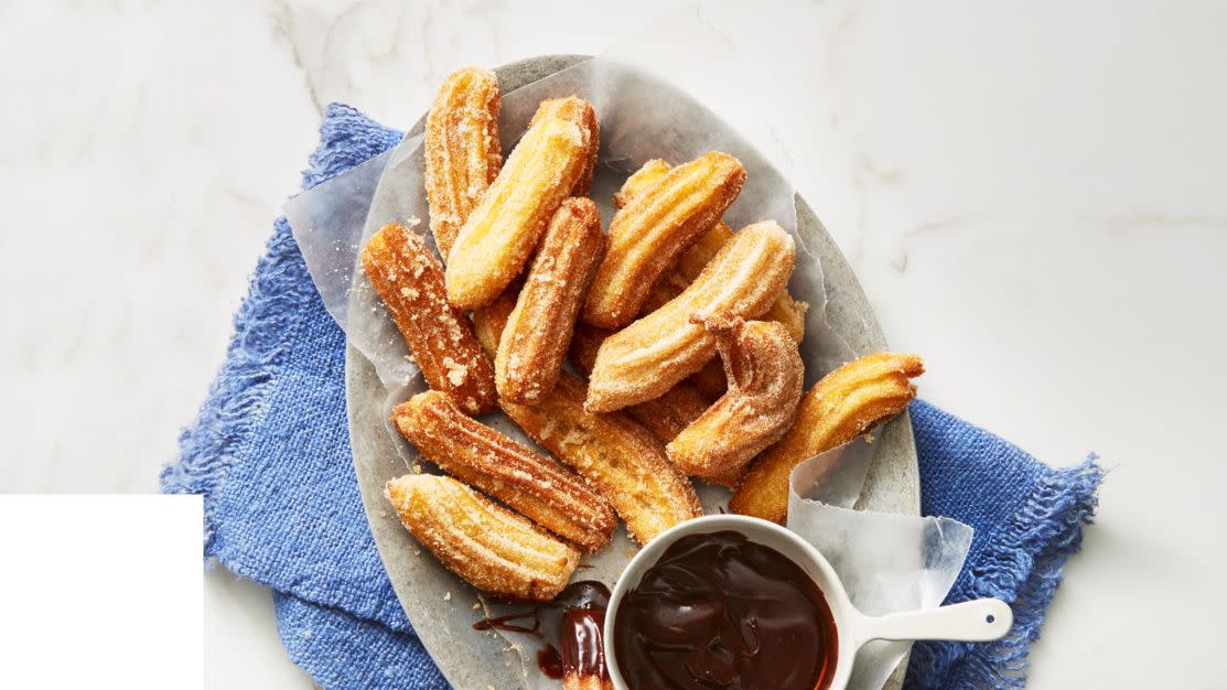 cinnamon churros with dipping chocolate on the side