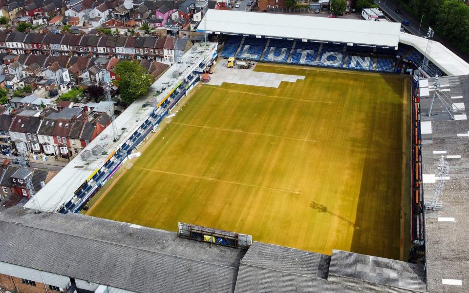 An aerial photo taken on May 31, 2023 shows Luton Town's Kenilworth Road stadium in Luton as members of the ground crew remove pitch lines and cover grass during end-of-season works.