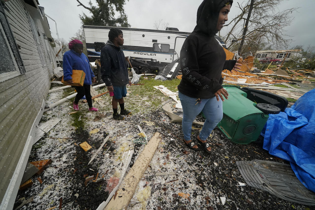 People walk through the rubble after a tornado tore through the area in Killona, La., about 30 miles west of New Orleans in St. James Parish, Wednesday, Dec. 14, 2022. (AP Photo/Gerald Herbert)