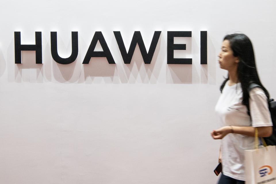 A woman walks past the Huawei logo during the Consumer Electronics Expo in Beijing on August 2, 2019. (Photo by FRED DUFOUR / AFP)        (Photo credit should read FRED DUFOUR/AFP/Getty Images)