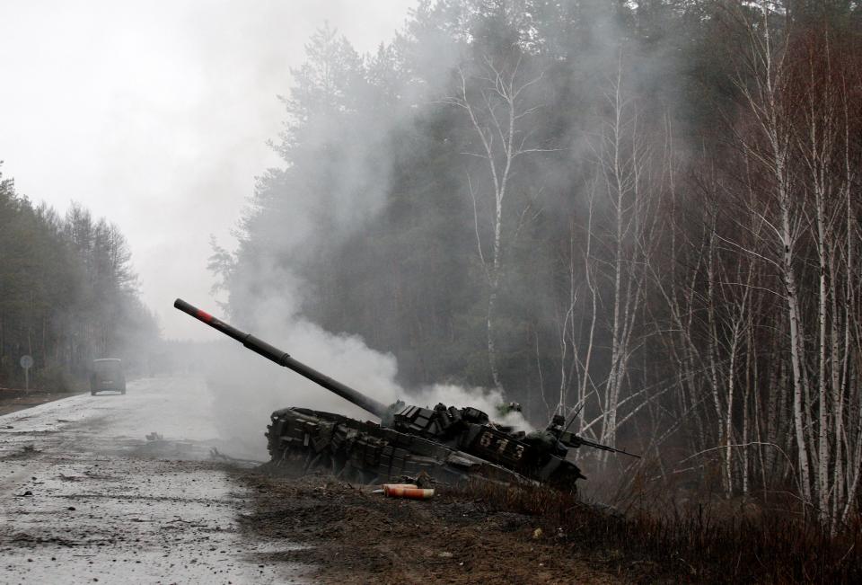 Smoke rises from a Russian tank destroyed by Ukrainian forces on the side of a road in Lugansk region on February 26, 2022.