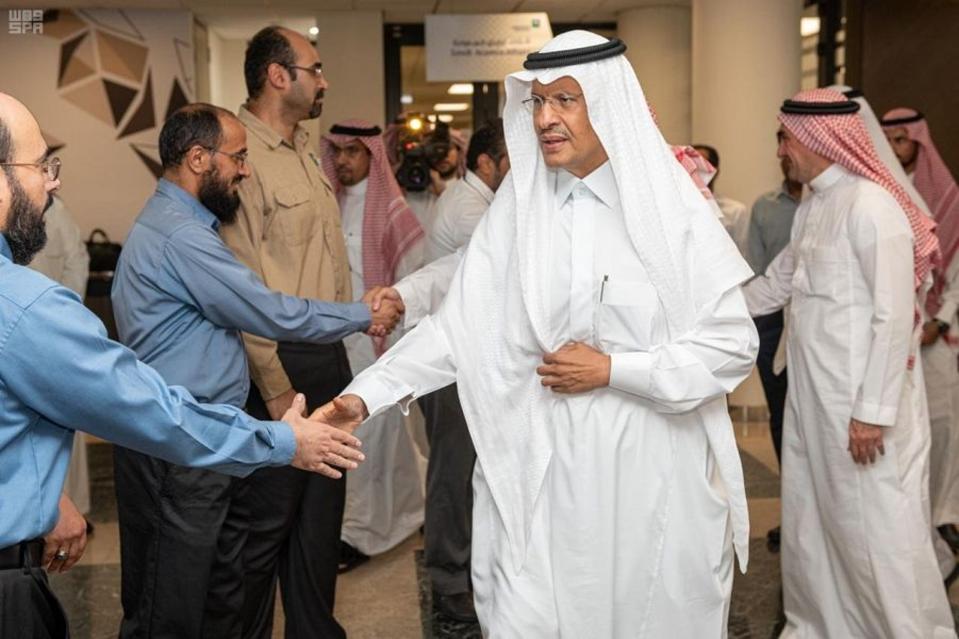 In this Sunday, Sept. 15, 2019, photo released by Saudi Press Agency, SPA, Saudi Energy Minister Prince Abdulaziz bin Salman, center, shakes hands with staff during his visit of the Saudi Aramco plants one day after the attacks in Abqaiq, Saudi Arabia. (Saudi Press Agency via AP)