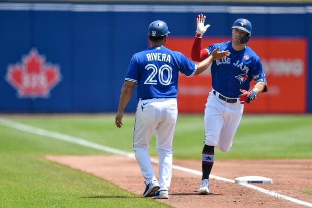 Toronto Blue Jays' Randal Grichuk, right, is congratulated after hitting a solo home run against the Tampa Bay Rays in Buffalo, N.Y. The Blue Jays could be back in Toronto by the end of July, pending the outcome of an application to the federal government. (Adrian Kraus/The Associated Press - image credit)