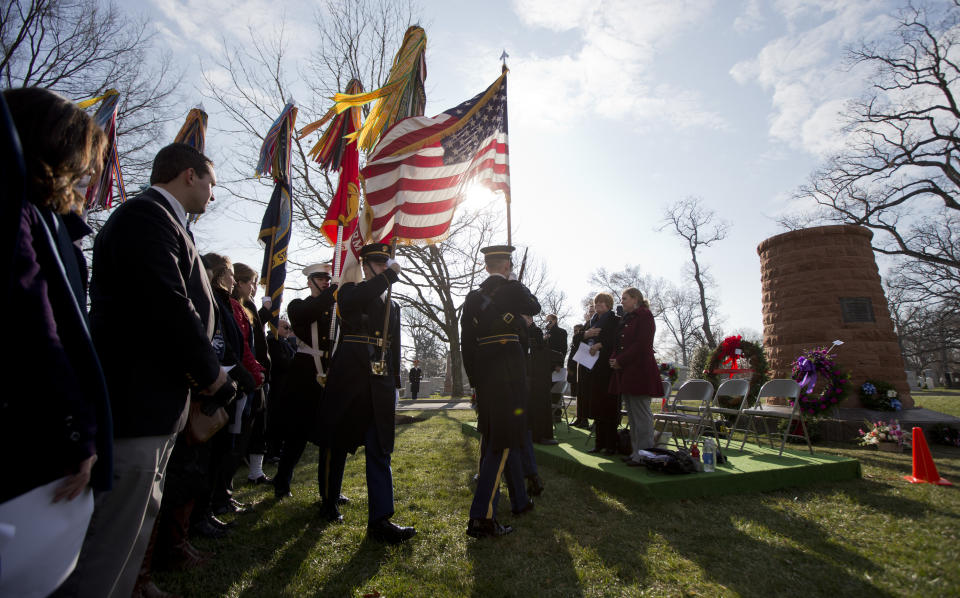 FILE - Honor guards carry the colors of the United States as relatives and friends of the victims of the bombing of Pan Am Flight 103 gather around the memorial cairn at Arlington National Cemetery, in Arlington, Va., Sunday, Dec. 21, 2014, during a memorial service to mark the 26th anniversary of the bombing of the Pan Am Flight 103 that crashed over Lockerbie, Scotland. U.S. and Scottish authorities said Sunday, Dec. 11, 2022 that the Libyan man suspected of making the bomb that destroyed a passenger plane over Lockerbie, Scotland, in 1988 is in U.S. custody. (AP Photo/Manuel Balce Ceneta, File)