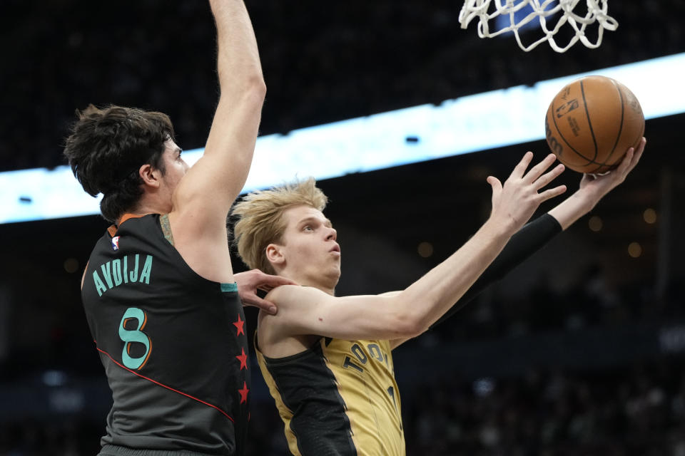 Toronto Raptors guard Gradey Dick, right, goes the basket as Washington Wizards forward Deni Avdija (8) defends during first-half NBA basketball game action in Toronto, Sunday, April 7, 2024. (Frank Gunn/The Canadian Press via AP)