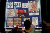 A fan uses a mobile phone to take pictures of late boxer Muhammad Ali's memorabilias of the 1970 bout with Joe Frazier, dubbed as "Thrilla in Manila" in Cubao Quezon City, Metro Manila, Philippines June 10, 2016. REUTERS/Erik De Castro