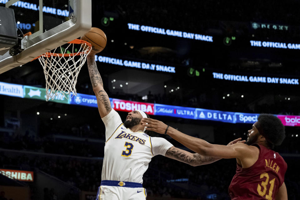 Los Angeles Lakers forward Anthony Davis (3) makes a lay-up under pressure from Cleveland Cavaliers center Jarrett Allen (31) during the first half of an NBA basketball game, Saturday, April 6, 2024, in Los Angeles. (AP Photo/William Liang)