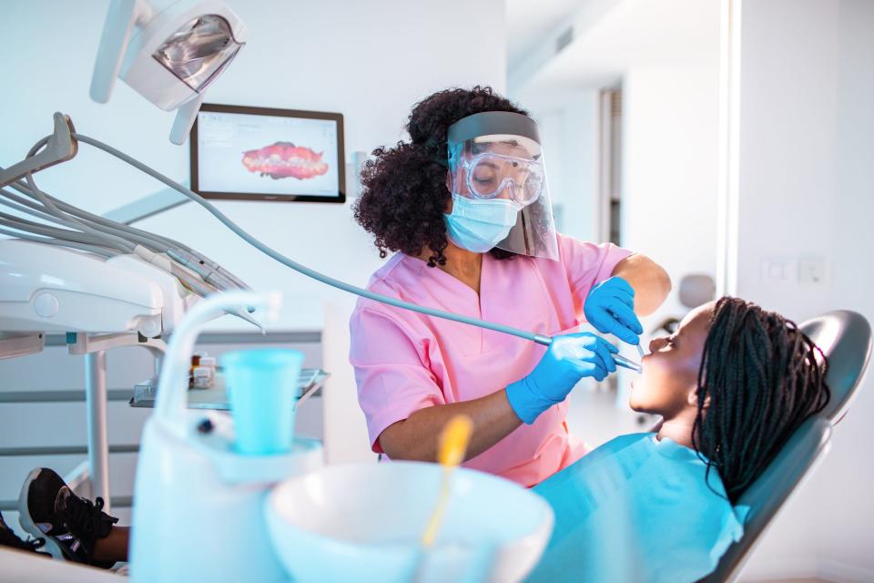 A dentist operates on a patient.