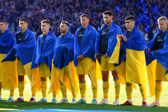 Seen here, Ukraine players wear the country's national flag draped over their shoulders before their World Cup qualifying play-off semi-final against Scotland.