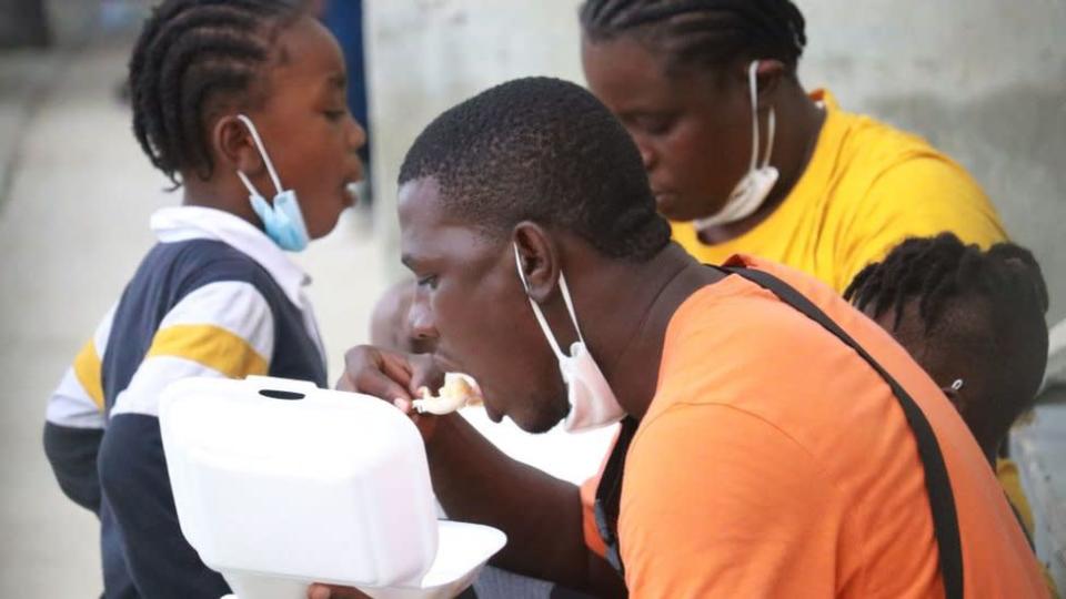Haitianos repatriando comiendo en el aeropuerto de Puerto Pr&#xed;ncipe.