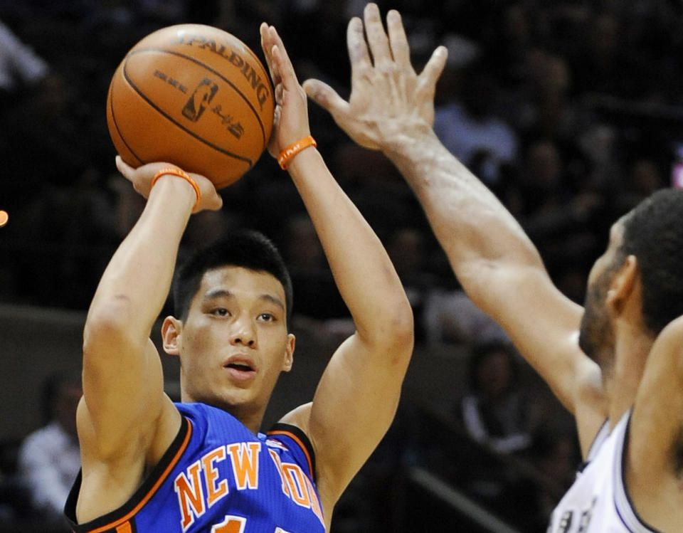 FILE - In this March 7, 2012 file photo, New York Knicks' Jeremy Lin, left, shoots over San Antonio Spurs' Tim Duncan during the first half of an NBA basketball game, in San Antonio. This would have been such an easy decision in February. Lin was the biggest thing in basketball, and no way the Knicks would have let him go elsewhere. Now, knowing his price and with no assurance he'll play as he did when Linsanity reigned, the Knicks may allow Lin to leave for Houston.  (AP Photo/Darren Abate, File)