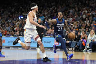 Minnesota Timberwolves guard Monte Morris (23) drives against Phoenix Suns guard Devin Booker during the second half of an NBA basketball game Friday, April 5, 2024, in Phoenix. (AP Photo/Rick Scuteri)