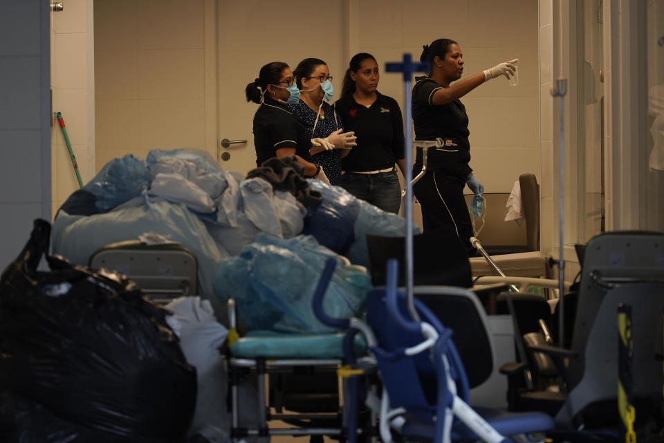 Hospital employees work next to medical equipments at the Badim Hospital, where a fire left at least 11 people dead, in Rio de Janeiro, Brazil, Friday, Sept. 13, 2019. The fire raced through the hospital forcing staff to wheel patients into the streets on beds or in wheelchairs. (AP Photo/Leo Correa)