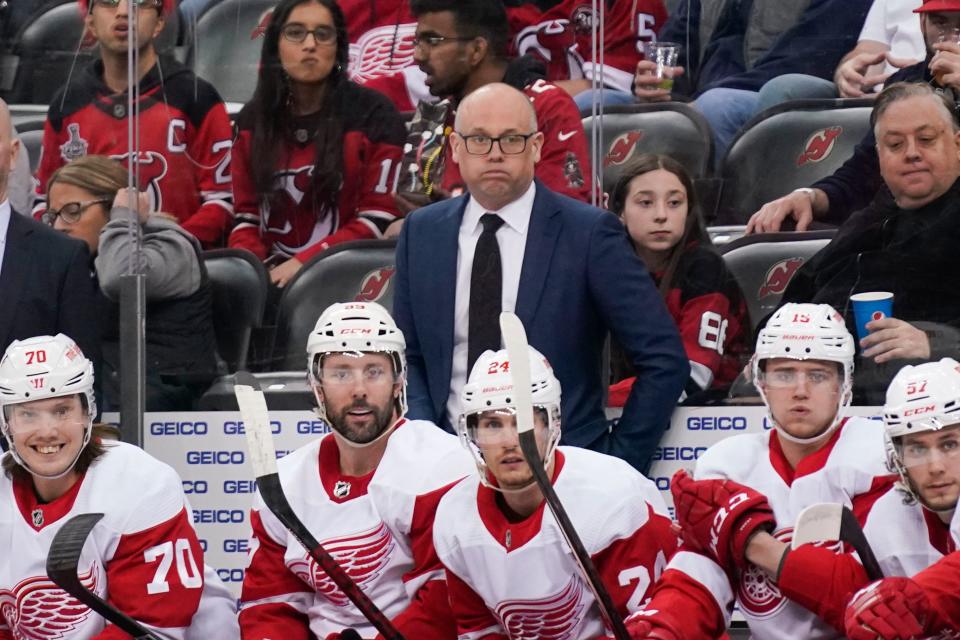 Detroit Red Wings head coach Jeff Blashill, center, looks over the ice during the first period against the New Jersey Devils at the Prudential Center in Newark, N.J., on Friday, April 29, 2022.