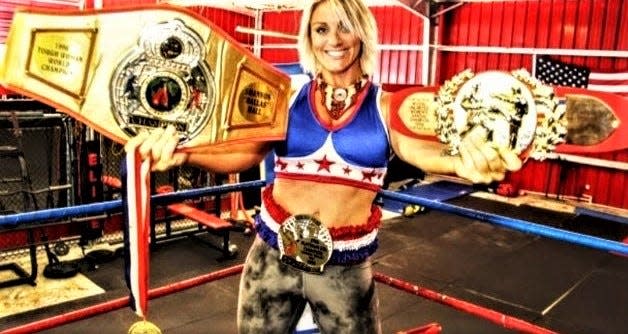 Shannon Hall-Girolamo shows off awards signifying her Toughwoman World Championship title, IFBA Platinum Division Boxing championship, Wushu San Shou tournament championship and an American Gladiator Alumni Champion medal.