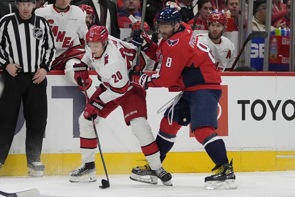 Carolina Hurricanes center Sebastian Aho (20) tries to keep the puck away from Washington Capitals left wing Alex Ovechkin (8) during the second period of an NHL hockey game Friday, Jan. 5, 2024, in Washington. (AP Photo/Mark Schiefelbein)