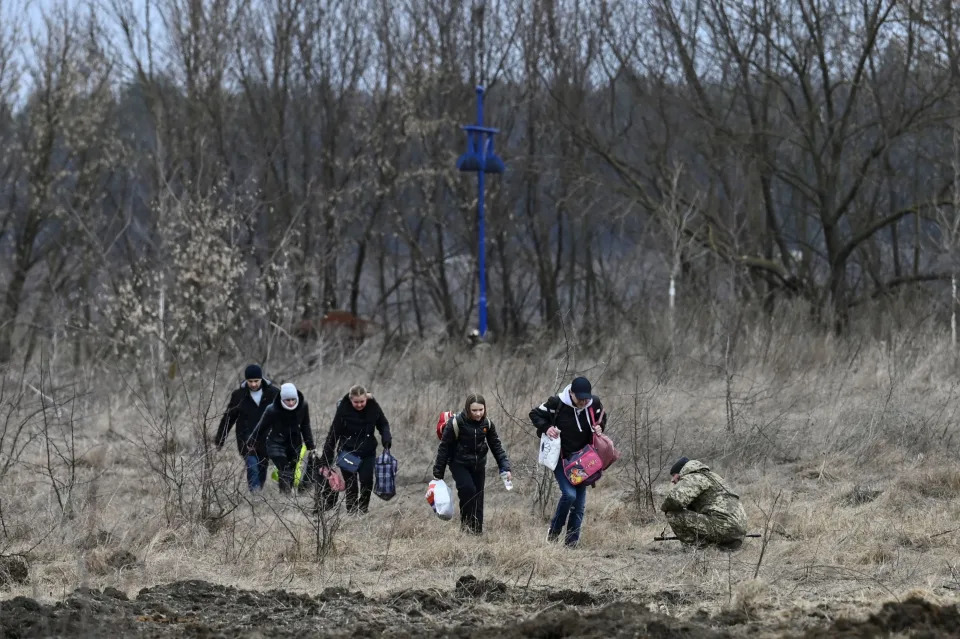 Pessoas fogem da cidade de Irpin, a oeste de Kiev, em 7 de março de 2022. (Foto de ARIS MESSINIS/AFP via Getty Images)