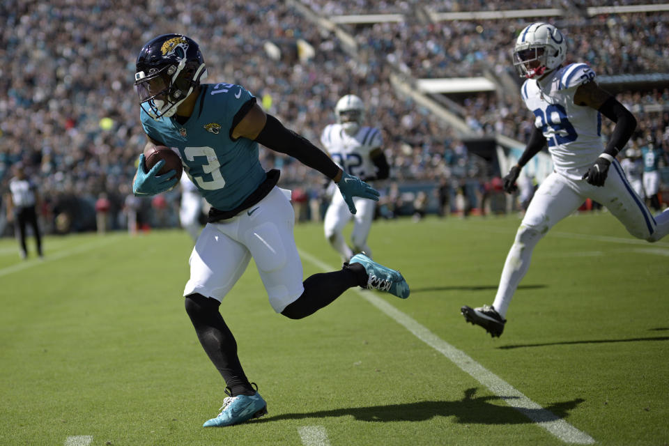 Jacksonville Jaguars wide receiver Christian Kirk (13) runs past Indianapolis Colts cornerback JuJu Brents (29) for a touchdown after a catch during the first half of an NFL football game, Sunday, Oct. 15, 2023, in Jacksonville, Fla. (AP Photo/Phelan M. Ebenhack)