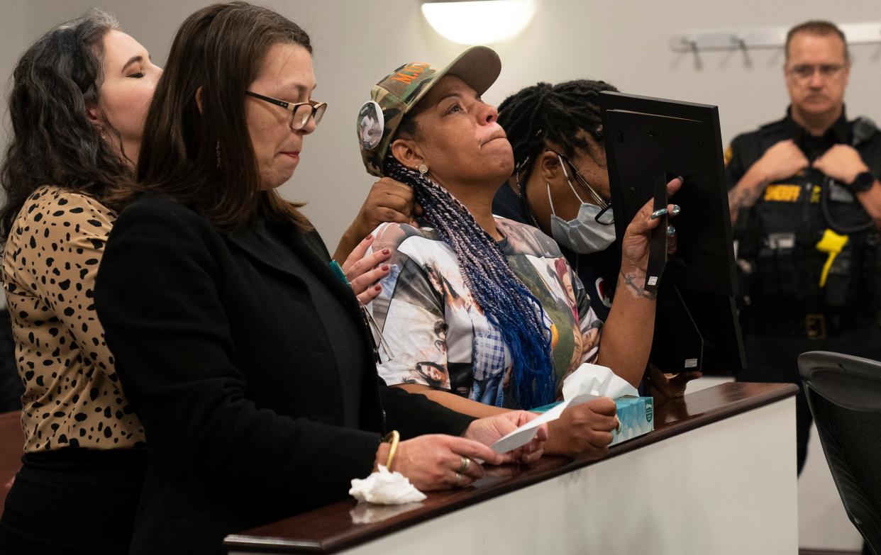 Shawna Brady, center, mother of slain 15-year-old TréVon Dickson, becomes emotional Thursday while her victim impact testimony is read before the sentencing of Nasir Ndiaye in Franklin County Court of Common Pleas Juvenile Division. Ndiaye, now 17, was 15 when he fatally shot Dickson in 2021 in an exchange of gunfire that also wounded Ndiaye. Brady is holding up a photo of her son for Ndiaye to see.