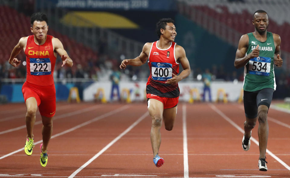 China's Xu Zhouzheng, left, Indonesia's Lalu Muhammad Zohri and Saudi Arabia's Abdullah Abkar Mohammed, right, run in their men's 100m semifinal during the athletics competition at the 18th Asian Games in Jakarta, Indonesia, Sunday, Aug. 26, 2018. (AP Photo/Bernat Armangue)