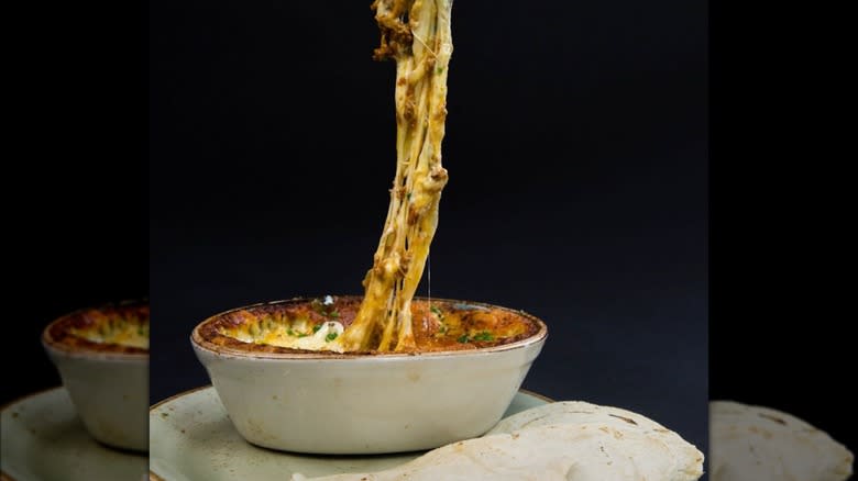 Queso fundido with long string of cheese