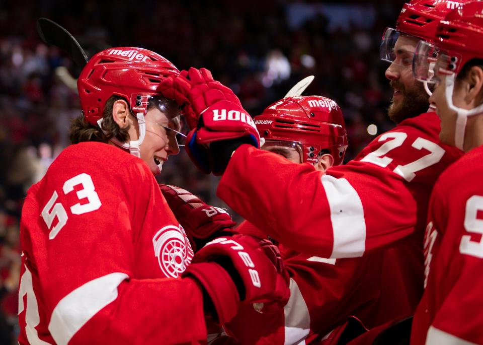 Detroit Red Wings defenseman Moritz Seider (53) celebrates with teammates after scoring the game winning goal in overtime against the New York Islanders at Little Caesars Arena on Dec. 4, 2021.