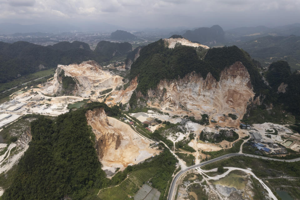 Deforested mountains from massive limestone quarries are seen in Ipoh, Perak state Malaysia, Friday, Nov. 5, 2021. Deforestation affects the people and animals where trees are cut, as well as the wider world and in terms of climate change, and cutting trees both adds carbon dioxide to the air and removes the ability to absorb existing carbon dioxide. World leaders are gathered in Scotland at a United Nations climate summit, known as COP26, to push nations to ratchet up their efforts to curb climate change. (AP Photo/Vincent Thian)