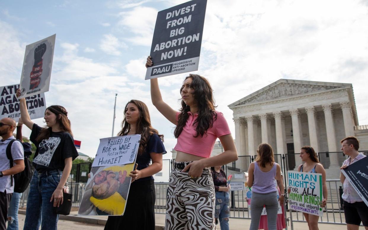 Anti-abortion demonstrators hold up signs outside the US Supreme Court - Amanda Andrade-Rhoades 