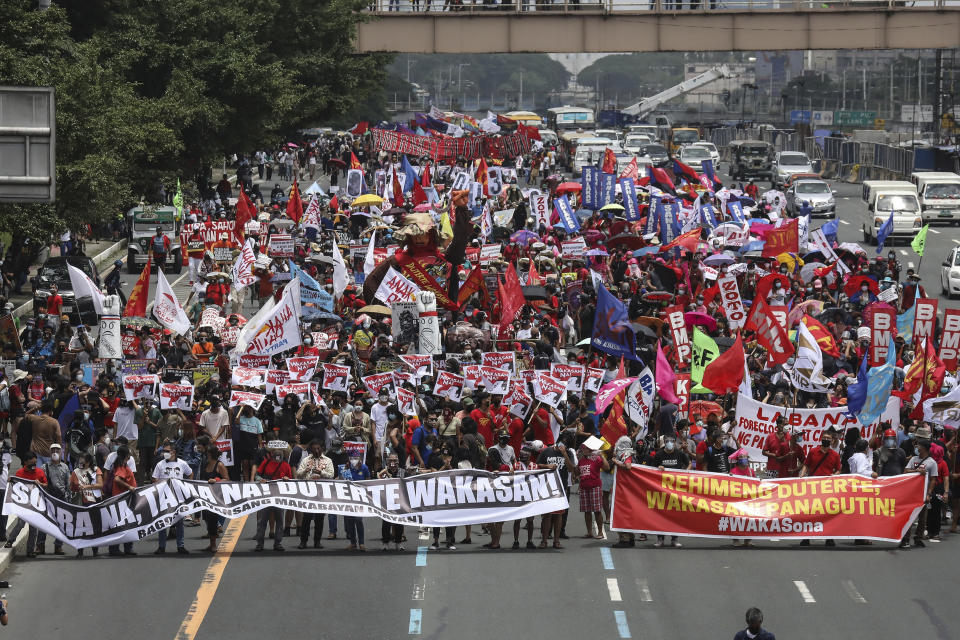 Protesters march towards the House of Representatives where Philippine President Rodrigo Duterte is set to deliver his final State of the Nation Address in Quezon city on Monday, July 26, 2021. Duterte is winding down his six-year term amid a raging pandemic and a battered economy. (AP Photo/Gerard Carreon)
