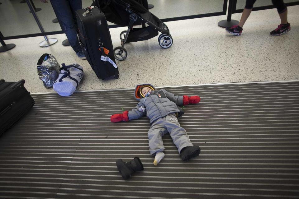 A child lies on the floor at JFK airport in New York