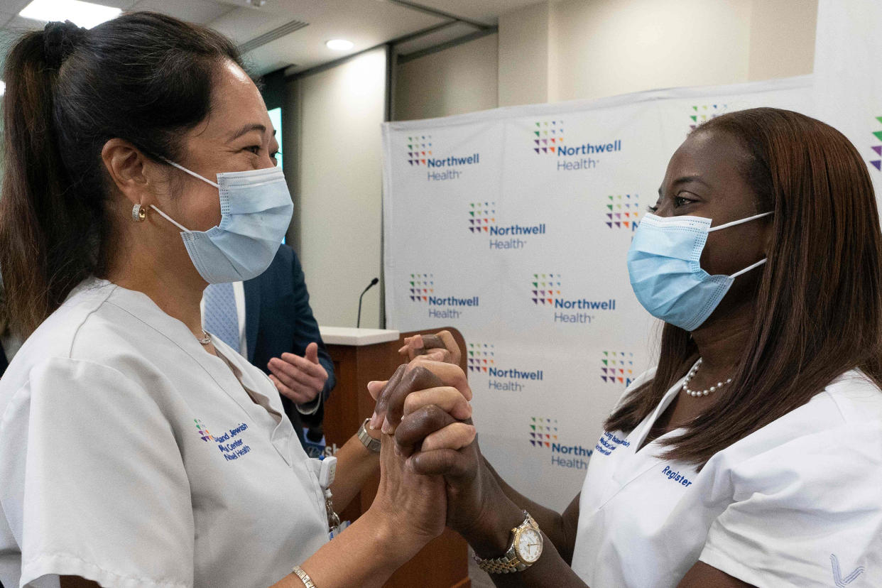 Nurse Annabelle Jimenez congratulates nurse Sandra Lindsay after she is inoculated with the Covid-19 vaccine, at Long Island Jewish Medical Center, in Queens, N.Y., on Dec. 14, 2020. (Mark Lennihan  / AP Pool file)