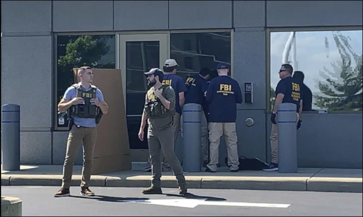 In this image taken from FOX19 Cincinnati video, FBI officials gather outside the FBI building in Cincinnati, Thursday, Aug. 11, 2022.