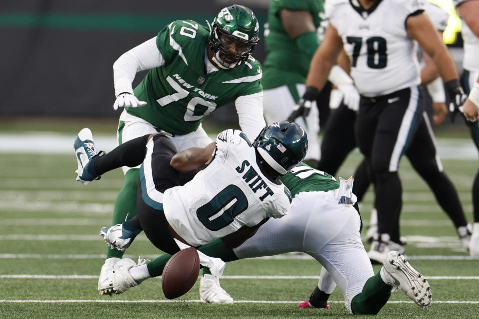 Philadelphia Eagles' D'Andre Swift (0), bottom, fumbles the ball during the first half of an NFL football game against the New York Jets, Sunday, Oct. 15, 2023, in East Rutherford, N.J. The New York Jets recovered the fumble. (AP Photo/Noah K. Murray)