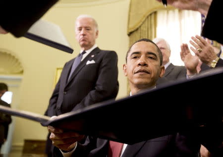 U.S. President Barack Obama signs an executive order regarding the closure of the U.S. military prison at Guantanamo Bay, Cuba with Vice President Joe Biden (L) at his side on his second official day as president at the White House in Washington, in this January 22, 2009 file picture. REUTERS/Larry Downing/Files