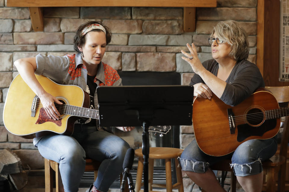 In this May 22, 2020, photo, nurse Megan Palmer, left, and care partner Anna Henderson, who both work at Vanderbilt University Medical Center, appear during a songwriting session at Henderson's home in Ashland City, Tenn. During the COVID-19 pandemic, their role as caregivers has become even more important as hospital visits from family and friends were limited or prohibited to prevent the spread of the virus. Music and songwriting has helped them express the complexity of emotions that comes with caregiving, especially in the time of a pandemic. (AP Photo/Mark Humphrey)