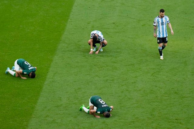 Argentina’s Lionel Messi leaves the field as three Saudi Arabia players kneel on the turf