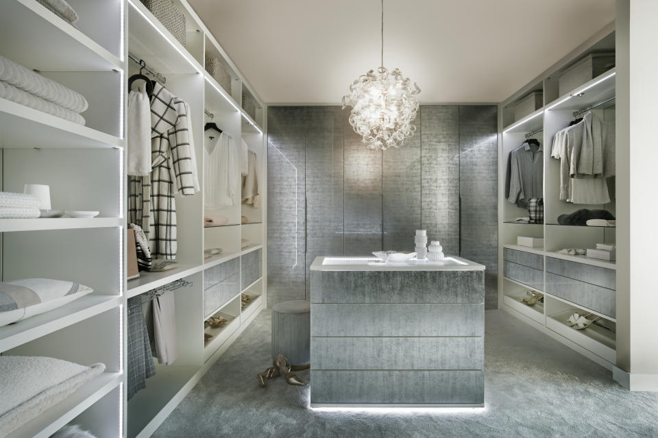 Walk-in closet with open shelves and hanging rails and gray finish