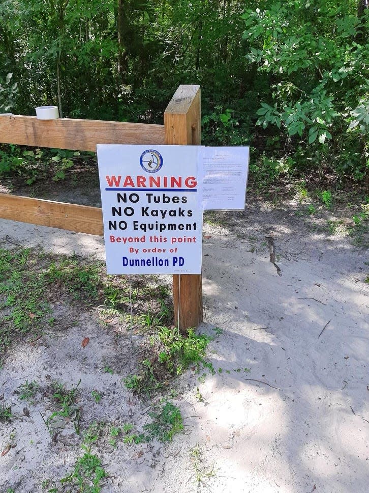 Warning sign about alligator at trail entrance