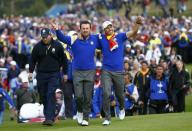 Team Europe players Graeme McDowell and Sergio Garcia (R) embrace as they walk up the 18th fairway during the 40th Ryder Cup at Gleneagles in Scotland September 28, 2014. REUTERS/Eddie Keogh