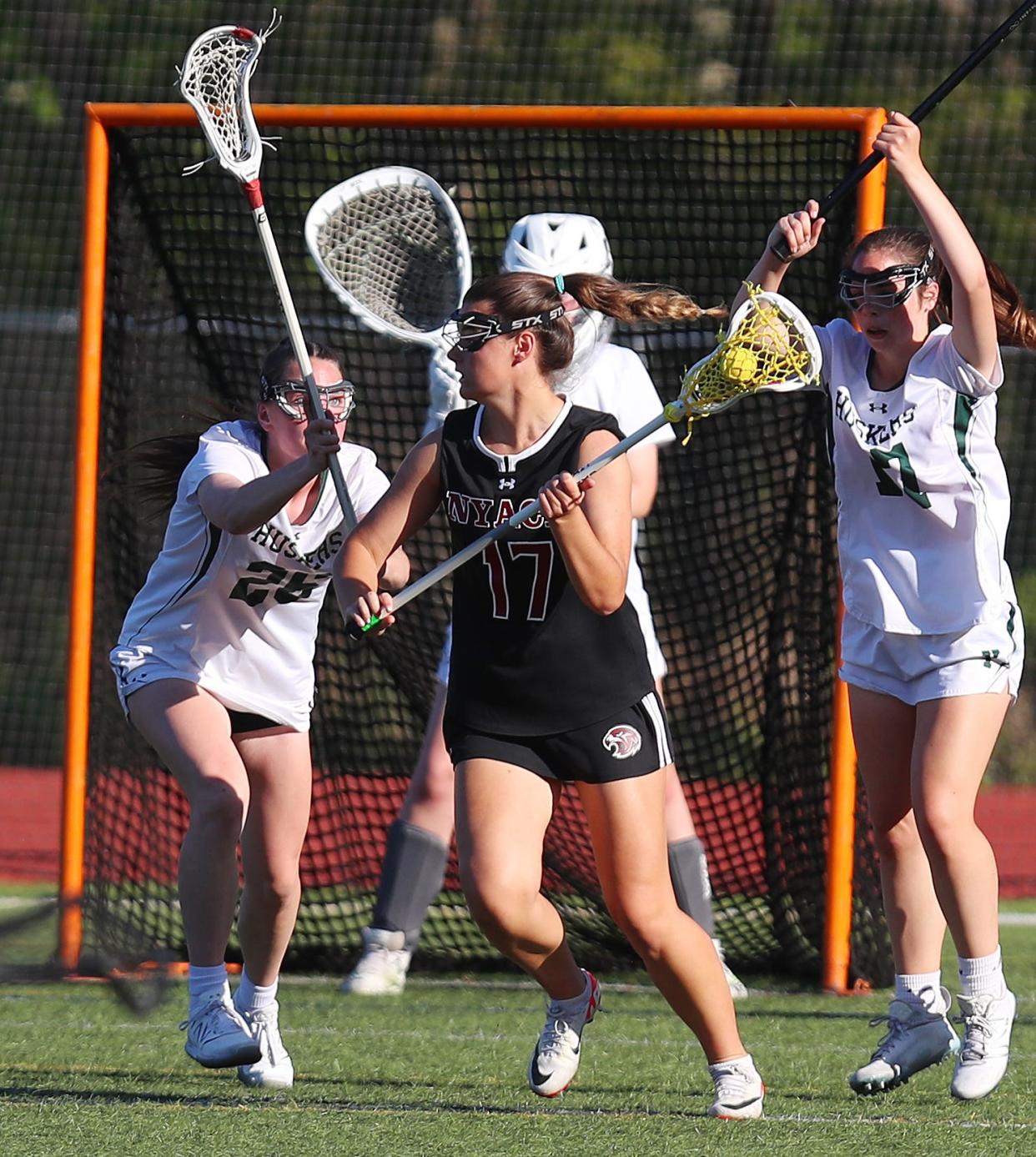 Yorktown's Reileigh McEnroe (l) defends as Nyack's Kayleigh Cassidy carries the ball in front of the Yorktown net during Nyack's 10-7 girls lacrosse win May 7, 2024 at Yorktown High School.