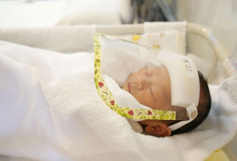 FILE PHOTO: A newborn baby wearing a face shield as a protection from the coronavirus disease (COVID-19), is seen at maternity hospital Wise Ladies' Clinic in Satte, Japan