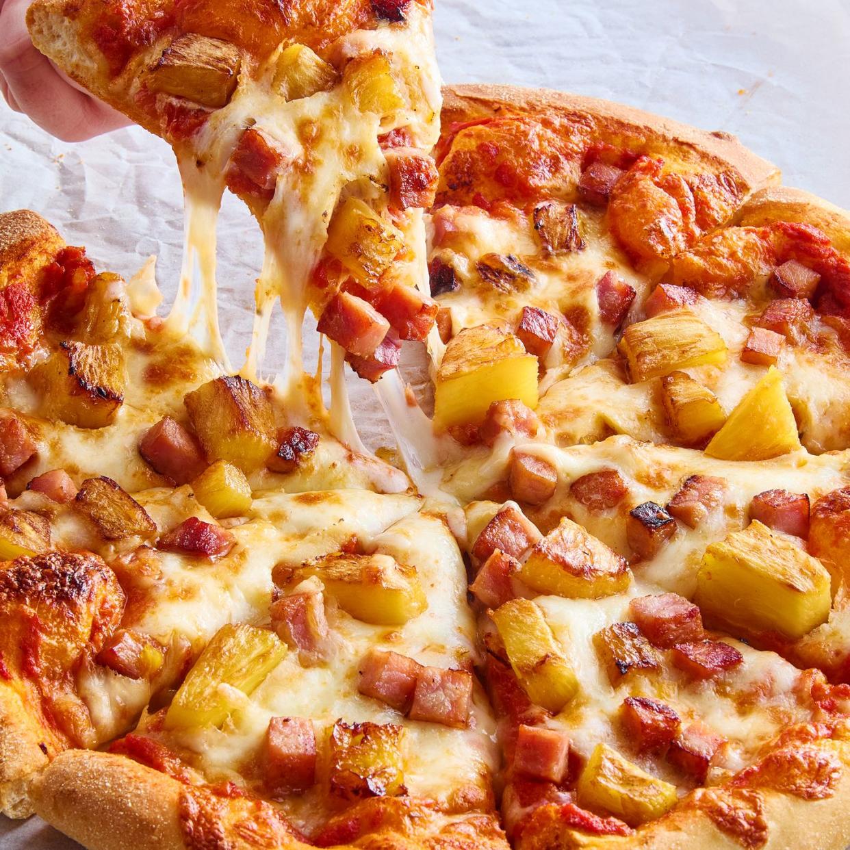 pizza topped with pineapple and pieces of ham