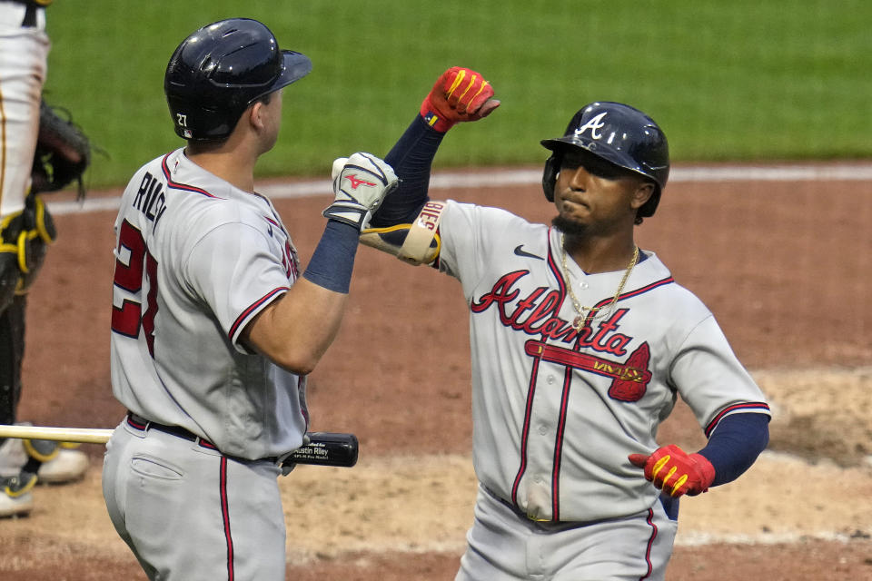 Atlanta Braves' Ozzie Albies, right, is greeted by Austin Riley, left, as he returns to the dugout after hitting a solo home run off Pittsburgh Pirates starting pitcher Osvaldo Bido during the fourth inning of a baseball game in Pittsburgh, Monday, Aug. 7, 2023. (AP Photo/Gene J. Puskar)