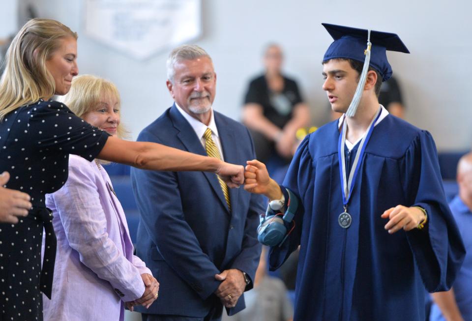 Graduate Adam Azouz gets a fist bump from Sarasota County School Board member Bridget Ziegler as he crosses the stage to receive his diploma at the Oak Park School Class of 2024 graduation May 17. Ziegler attended with other board members.